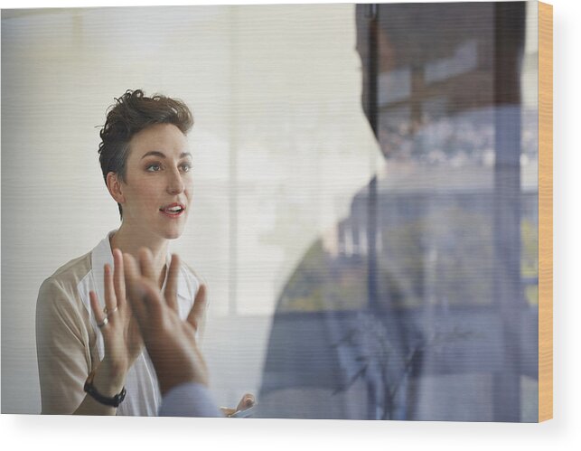 Expertise Wood Print featuring the photograph Businesswoman having discussion with male coworker by Klaus Vedfelt