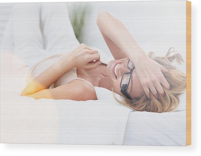 Moving To Lying Down Position Wood Print featuring the photograph Cheerful young woman on bed wearing smart glasses by Dean Mitchell
