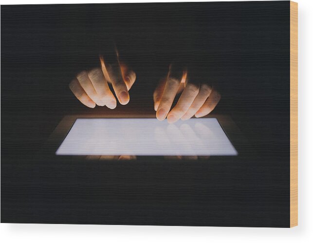 Using Digital Tablet Wood Print featuring the photograph Close up of human hands typing on digital tablet against black background by D3sign