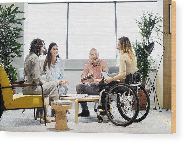 Young Men Wood Print featuring the photograph Disabled professional with coworkers in meeting by Morsa Images