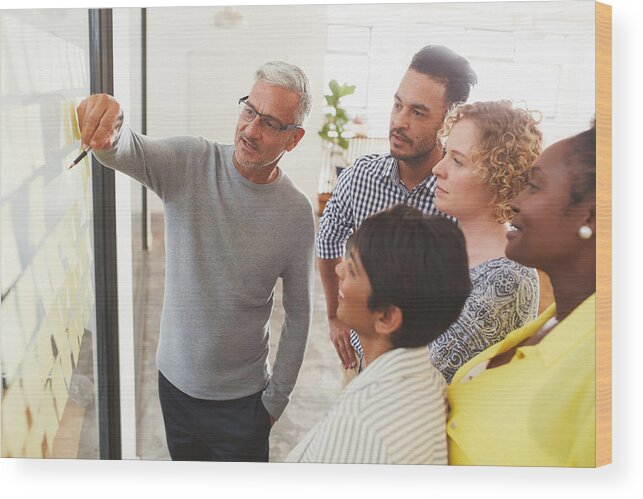 Expertise Wood Print featuring the photograph Diverse businesspeople brainstorming with adhesive notes in a meeting by Goodboy Picture Company