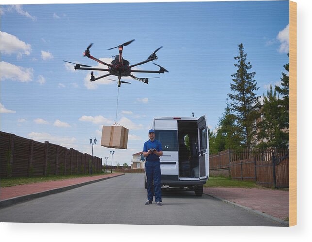People Wood Print featuring the photograph Drone delivery of goods by CliqueImages