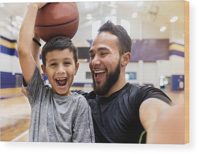 Education Wood Print featuring the photograph Father takes selfie while son holds a basketball on head by SDI Productions