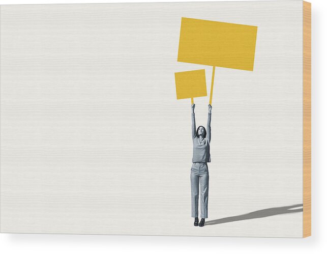 Shadow Wood Print featuring the photograph Female protestor holding blank yellow placards by Klaus Vedfelt