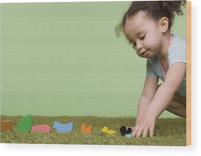 Toddler Wood Print featuring the photograph Girl playing with wooden animals by Image Source