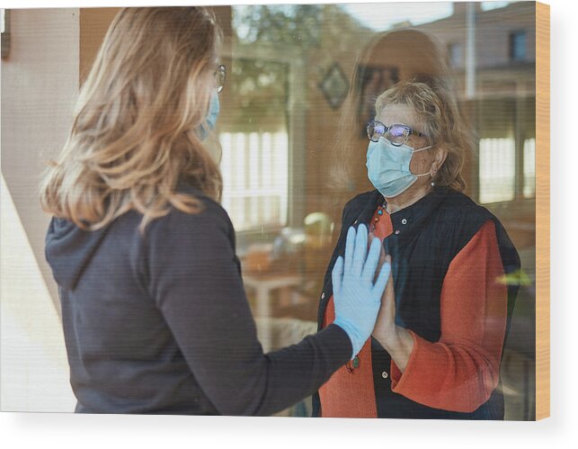 Protective Face Mask Wood Print featuring the photograph Granddaughter visiting grandmother during pandemic by Xavierarnau