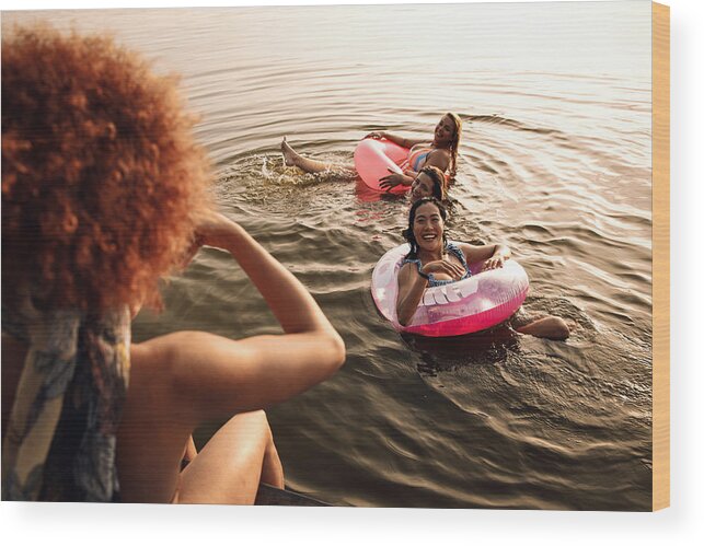 People Wood Print featuring the photograph Group of female friends enjoying a summer day swimming at the lake. by Zoran Zeremski
