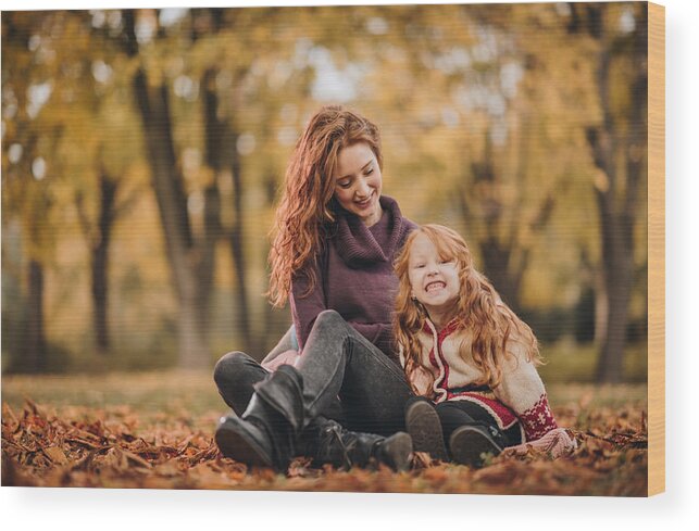 Child Wood Print featuring the photograph Happy redhead mother and daughter relaxing in the park. by Skynesher