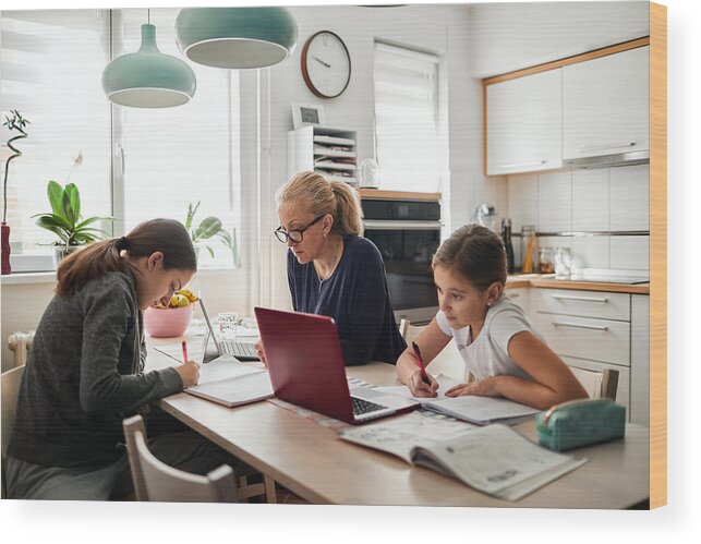 Internet Wood Print featuring the photograph Homeschooling - Mother Helping To Her Daughters To Finish School Homework During Coronavirus Quarantine by Vgajic