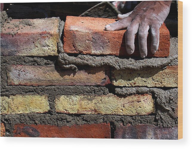 Working Wood Print featuring the photograph Human hand building brick wall by Memo Vasquez