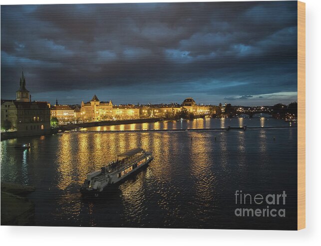 Architecture Wood Print featuring the photograph Illuminated Moldova River With Ship And Buildings In The Night In Prague In The Czech Republic by Andreas Berthold
