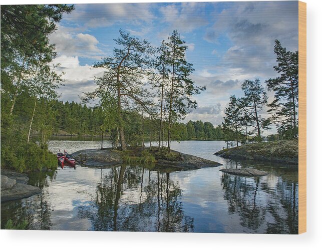 Water's Edge Wood Print featuring the photograph Lake with trees and rocks in the Dalsland Lake District in Sweden. by Sjo