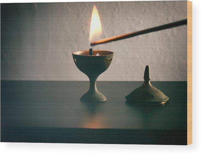 Tranquility Wood Print featuring the photograph Long match lighting an incense cone. by Harpazo_hope