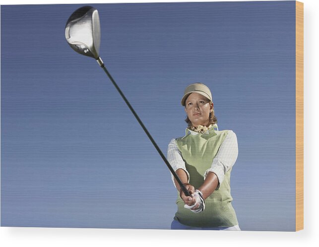 Sweater Wood Print featuring the photograph Low Angle View of a Woman Swinging a Golf Club by John Cumming