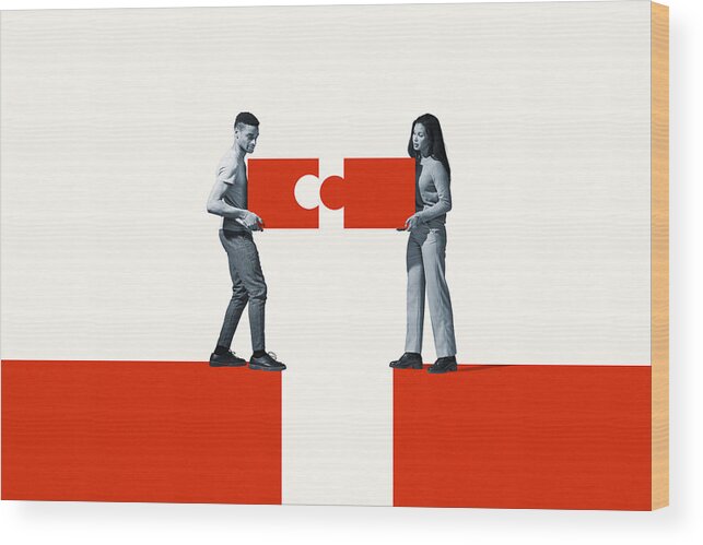 Young Men Wood Print featuring the photograph Man and woman positioning orange puzzle pieces by Klaus Vedfelt