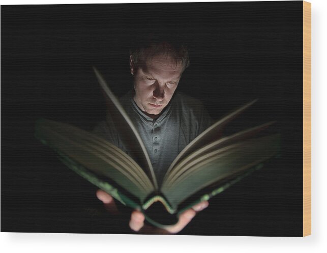 Nottinghamshire Wood Print featuring the photograph Man Reading Book Illuminated by Light by Nuzulu