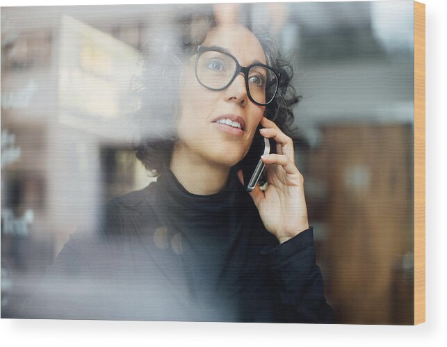 Working Wood Print featuring the photograph Mature woman inside a cafe talking on mobile phone by Luis Alvarez