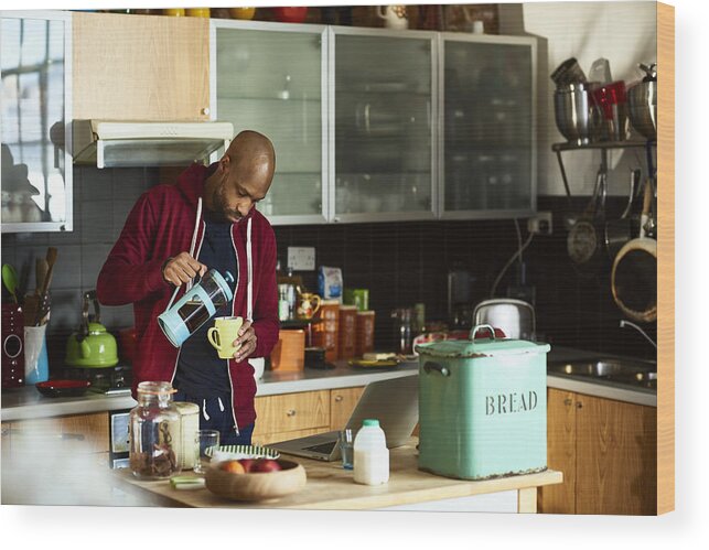 Breakfast Wood Print featuring the photograph Mid adult man in kitchen pouring freshly made coffee by 10'000 Hours