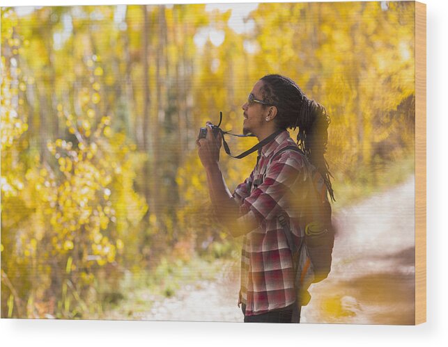 Three Quarter Length Wood Print featuring the photograph Mixed race hiker taking photograph in forest by Marc Romanelli