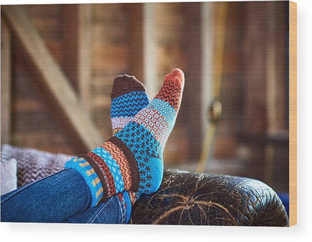Tranquility Wood Print featuring the photograph Person wearing patterned socks with feet up on leather sofa by 10'000 Hours