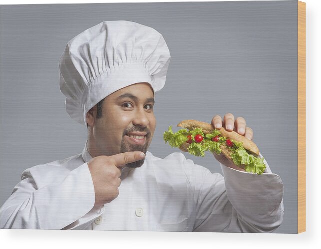 Young Men Wood Print featuring the photograph Portrait of chef pointing at sandwich by Ravi Ranjan