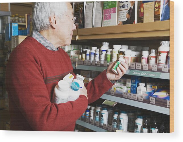 Pharmacy Wood Print featuring the photograph Senior Asian man shopping for natural medicine by Tanya Constantine
