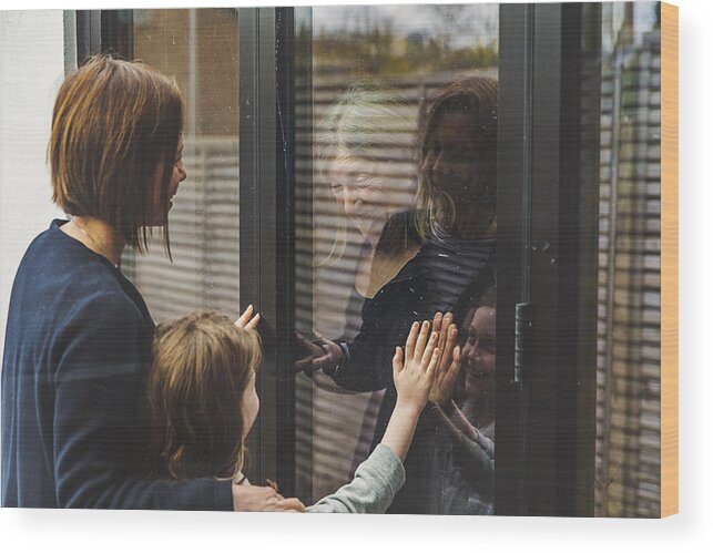 Cold And Flu Wood Print featuring the photograph Senior lady speaking to daughter and granddaughter through window by Justin Paget