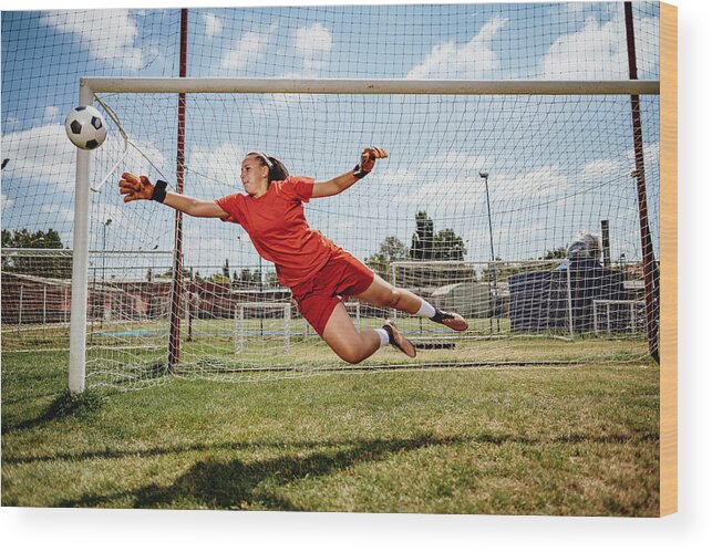 Goal Wood Print featuring the photograph Soccer penalty kick with teen female goalkeeper by Drazen_