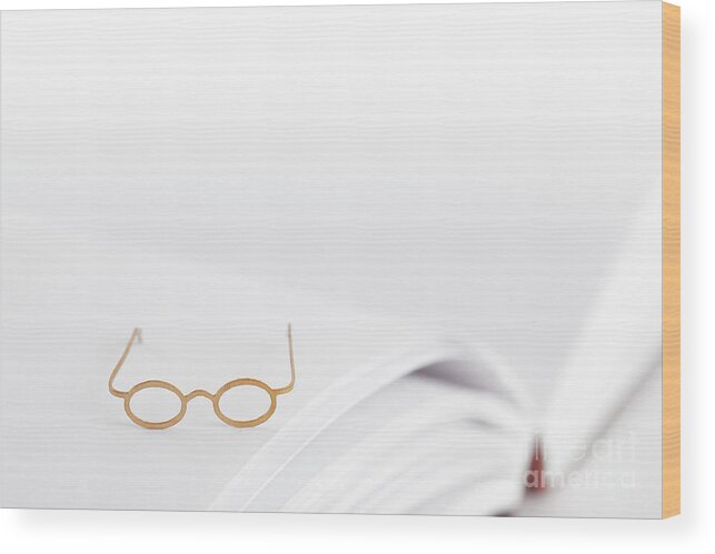 Reading Glasses Wood Print featuring the photograph Tiny reading glasses on open book by Simon Bratt