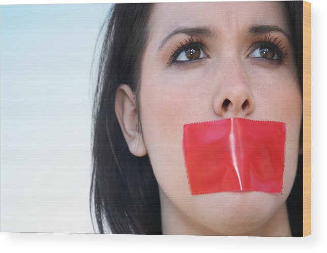 People Wood Print featuring the photograph Woman With Red Tape Over Her Mouth Unable To Speak by SDI Productions