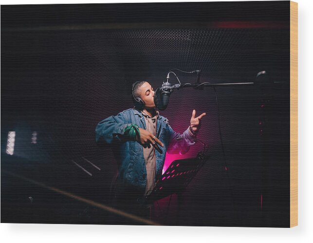 Performer Wood Print featuring the photograph Young hipster African-American rapper recording songs in music recording studio by Wundervisuals