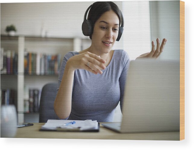 Working Wood Print featuring the photograph Young woman having video call on laptop computer at home by Damircudic