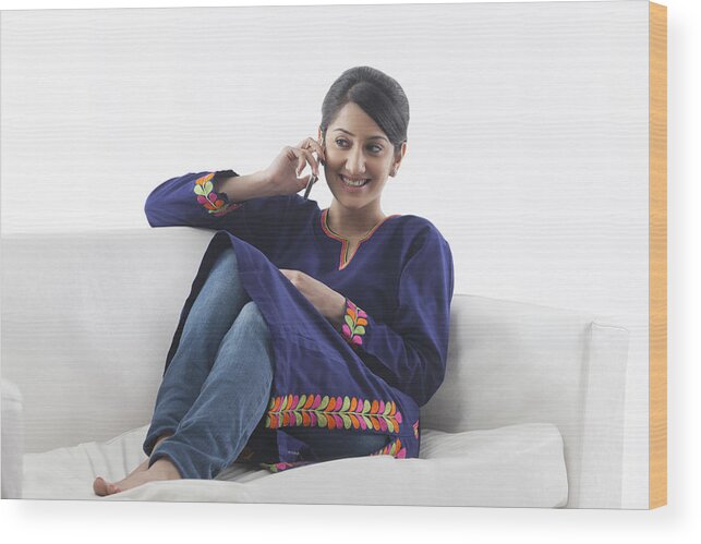 White Background Wood Print featuring the photograph Young woman talking on her cell phone by Hemant Mehta