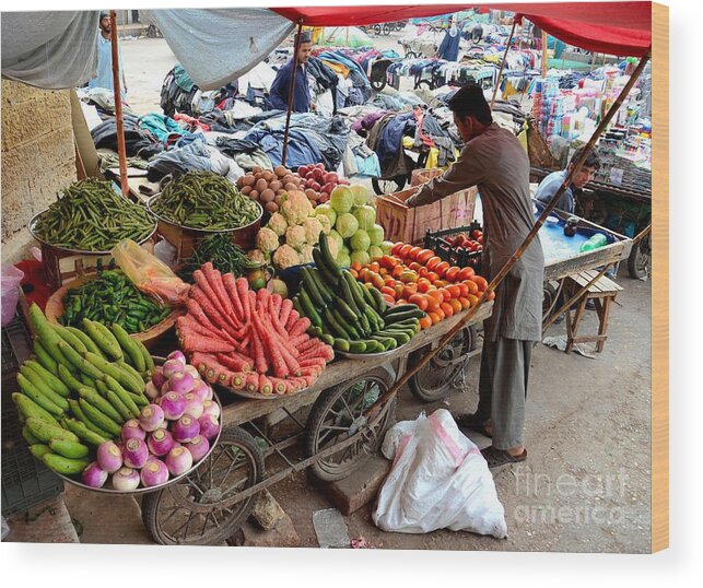 Fruits Wood Print featuring the photograph Fruit and vegetable seller tends to his cart outside Empress Market Karachi Pakistan by Imran Ahmed