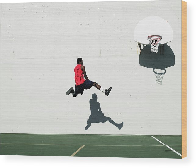 Shadow Wood Print featuring the photograph Teenage Boy 16-18 Dunking Basketball On by Thomas Barwick