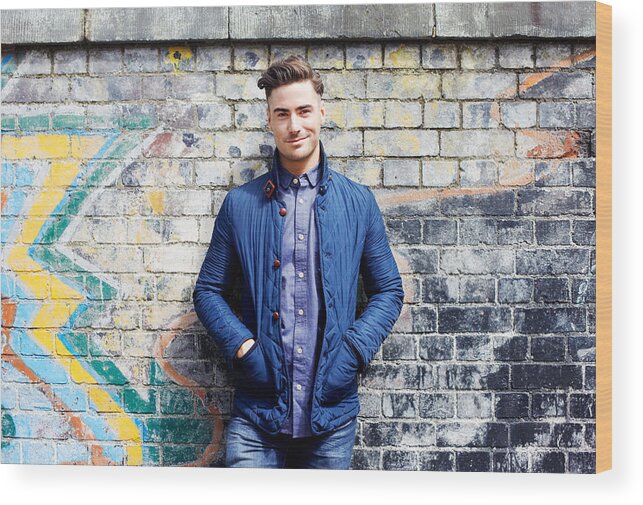 Cool Attitude Wood Print featuring the photograph Portrait of young man against wall. by Tim Robberts