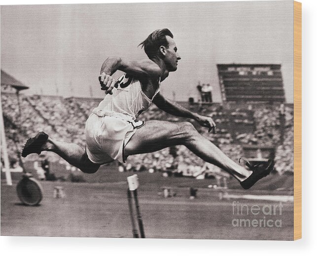 The Olympic Games Wood Print featuring the photograph Roy Cochran Going Over Hurdle by Bettmann