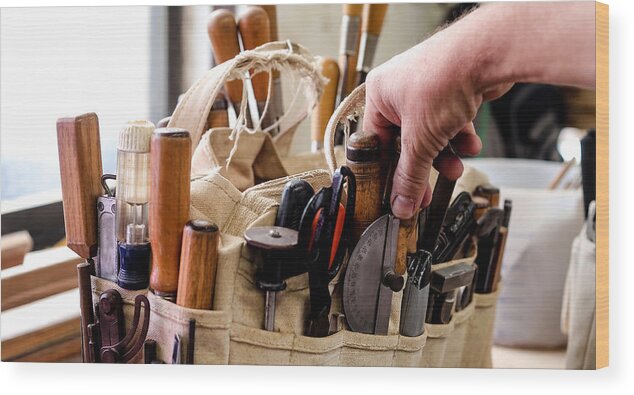 Expertise Wood Print featuring the photograph Man selecting a hand tool from a bag on workbench by Gary John Norman