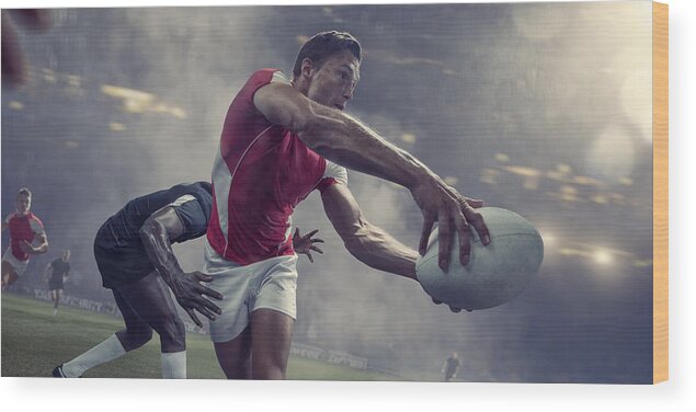 Teamwork Wood Print featuring the photograph Rugby Player About To Pass Ball Just Before Being Tackled by Peepo