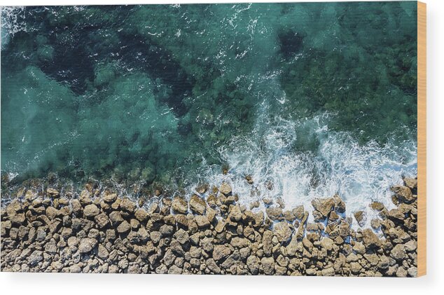 Seascape Wood Print featuring the photograph Aerial view from flying drone of crystal blue ocean water and sea wall. by Michalakis Ppalis