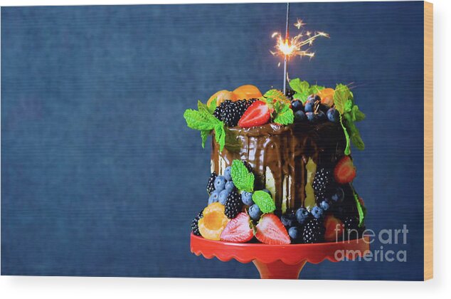Birthday Wood Print featuring the photograph Chocolate drip cake decorated with fresh fruit and berries with copy space. by Milleflore Images