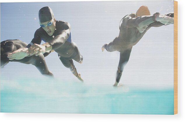 Sky Wood Print featuring the photograph Triathletes in wetsuits running into ocean by Caia Image