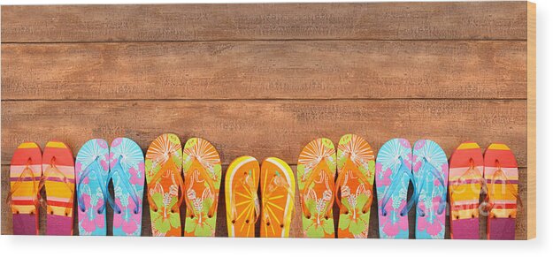 Beach Wood Print featuring the photograph Brightly colored flip-flops on wood by Sandra Cunningham