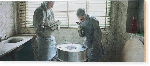 Young Men Wood Print featuring the photograph Two people in a room, woman holding magnifying glass by Matthieu Spohn