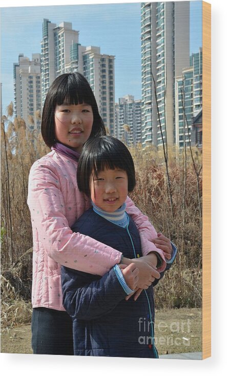 Girls Wood Print featuring the photograph Two Chinese teen sisters hug and embrace Shanghai China by Imran Ahmed