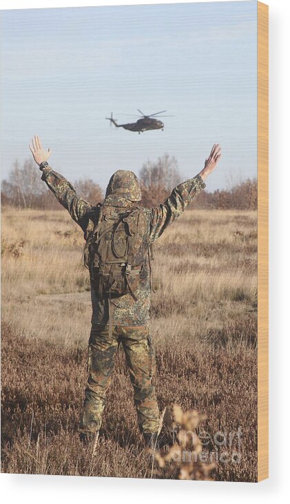 Germany Wood Print featuring the photograph A German Army Soldier Guides A Ch-53gs by Timm Ziegenthaler