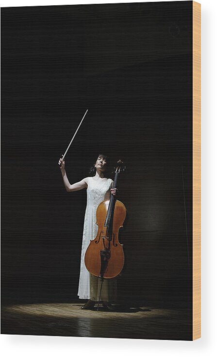 Human Arm Wood Print featuring the photograph A Female Cellist Raising Bow Of Cello by Sot