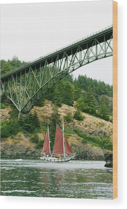 Sailboat Wood Print featuring the photograph A Sailboat Under The Deception Pass Bridge In Anacortes, Washington by Cavan Images