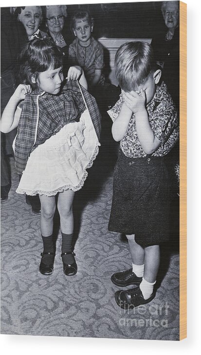 Confusion Wood Print featuring the photograph Boy Covering Eyes As Girl Raises Skirt by Bettmann