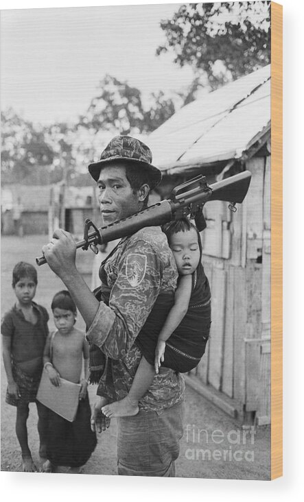 Problems Wood Print featuring the photograph Montagnard Soldier Carrying Baby by Bettmann